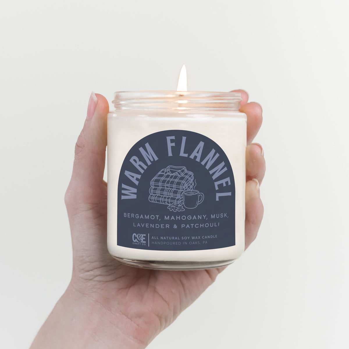 Warm Flannel scented candle, lit in hand